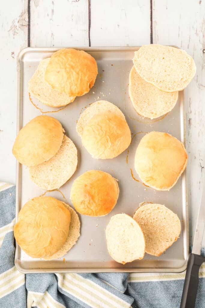 sliced homemade onion rolls on a baking sheet showing soft interior texture