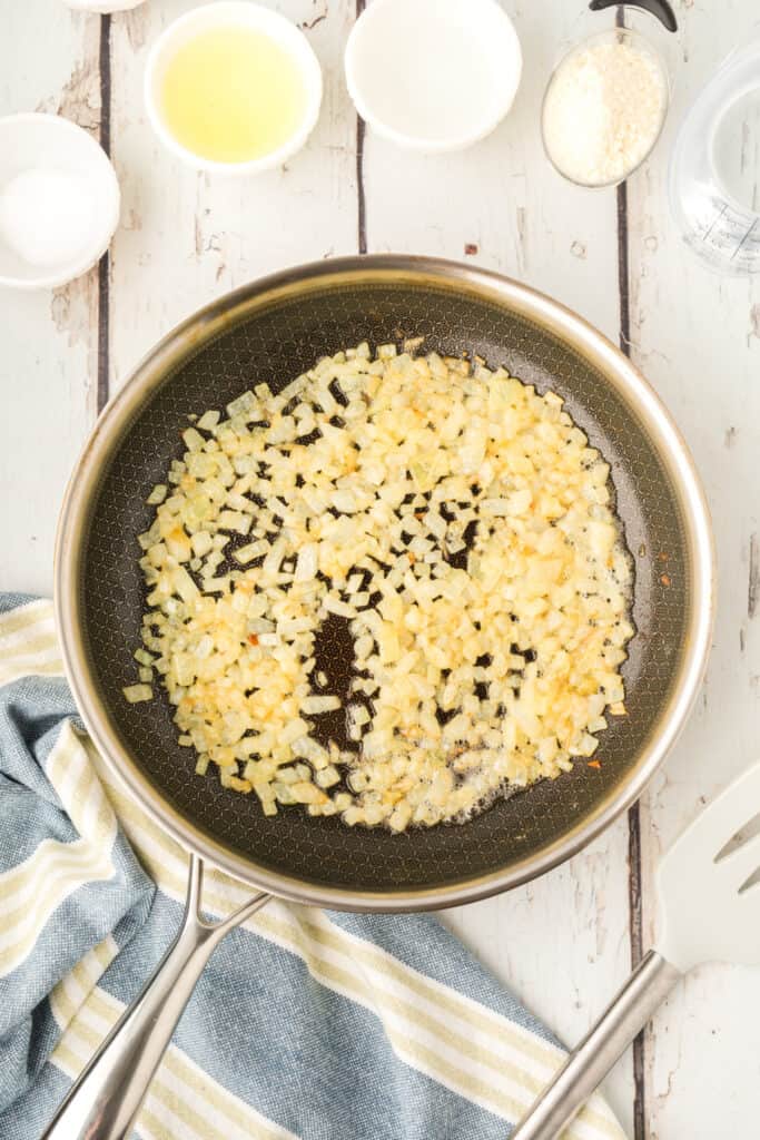 chopped onions cooking in butter in a skillet until softened and lightly golden