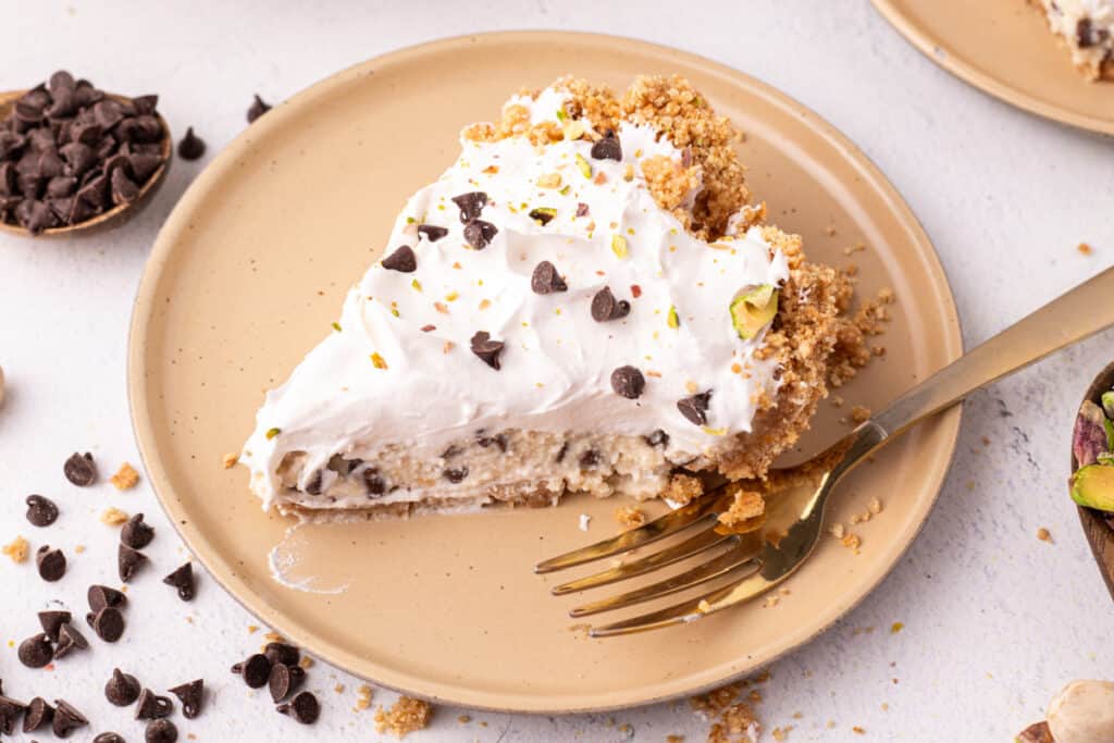 close cropped view of a slice of no bake cannoli pie focusing on the filling and crust texture