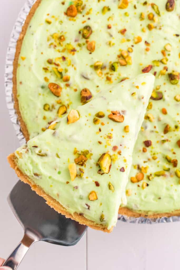 slice of pistachio cream pie being lifted from pie with a spatula