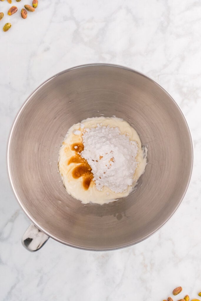 cream cheese with powdered sugar and vanilla extract in a mixing bowl