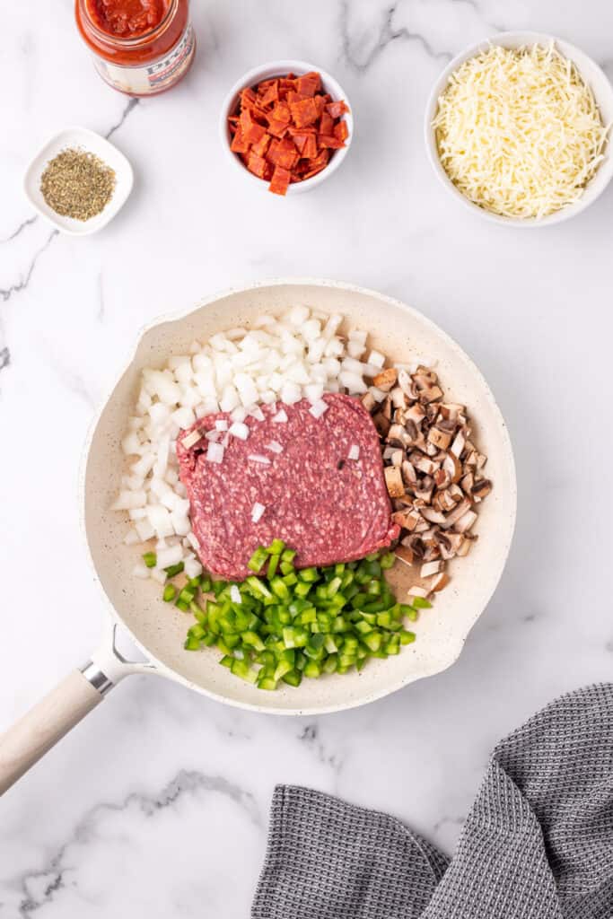 ground beef, chopped onion, green pepper, and mushrooms in a skillet before cooking for Pizza Sloppy Joes