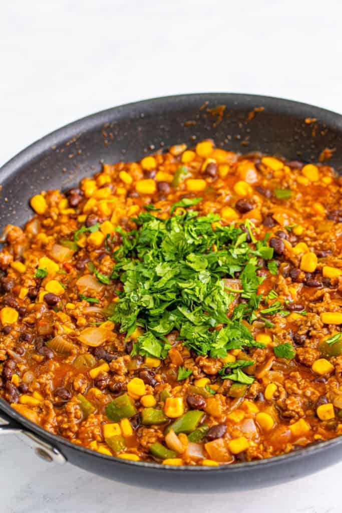 chopped cilantro added on top of Taco Sloppy Joes mixture in skillet