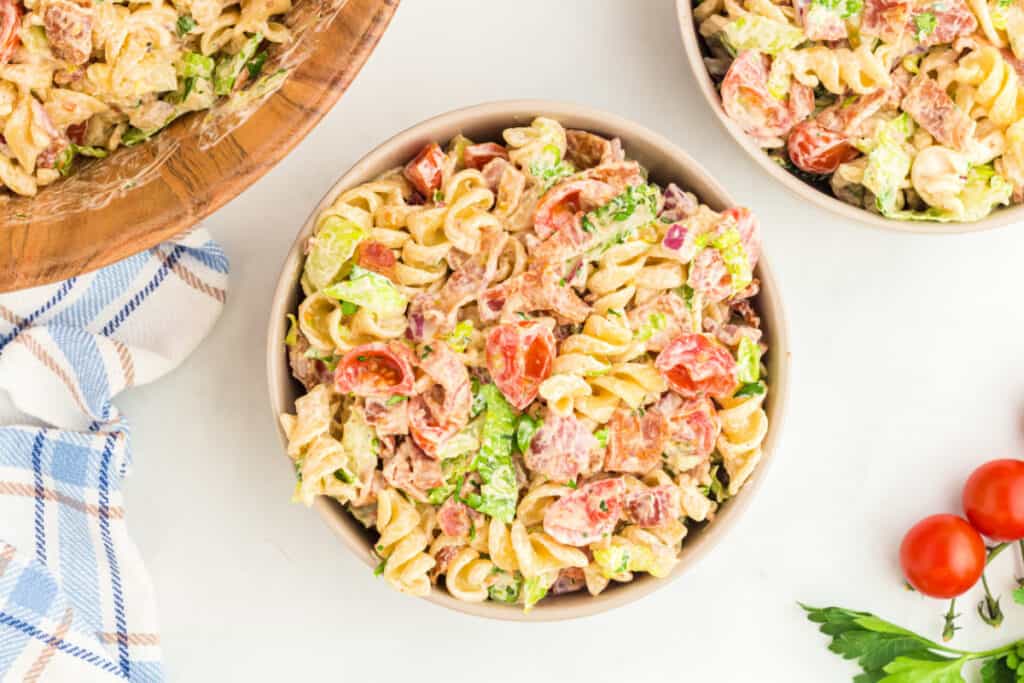 close up of BBQ Ranch BLT Pasta Salad in a bowl showing pasta, bacon, lettuce, tomatoes, and creamy dressing
