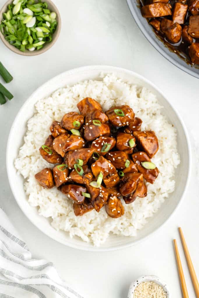 Bowl of Chicken Teriyaki served over white rice with green onions and sesame seeds