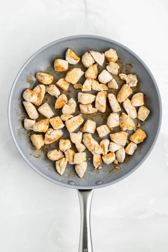 Bite-sized chicken pieces cooking in a skillet for easy Chicken Teriyaki