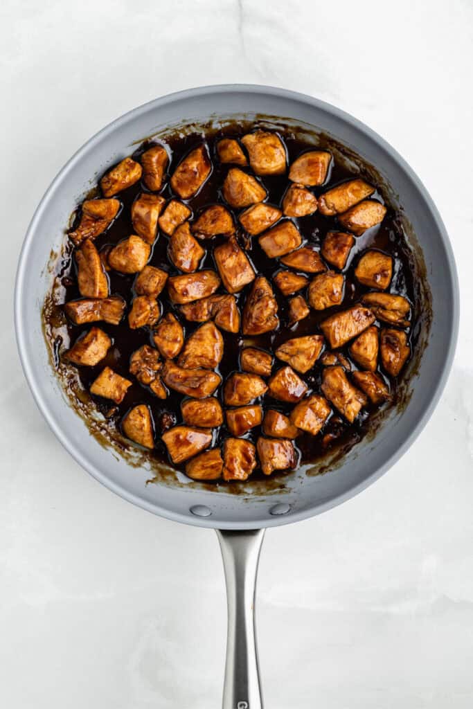 Chicken Teriyaki cooking in a skillet with thick glossy homemade teriyaki sauce