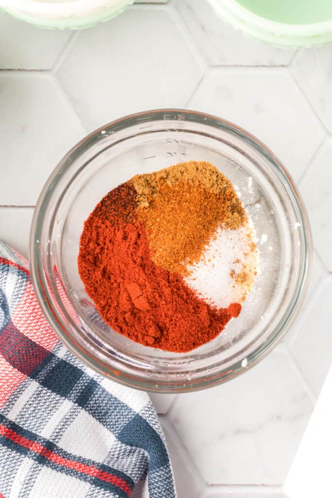 Spices and seasonings in a glass bowl for Homemade Fajita Seasoning before mixing