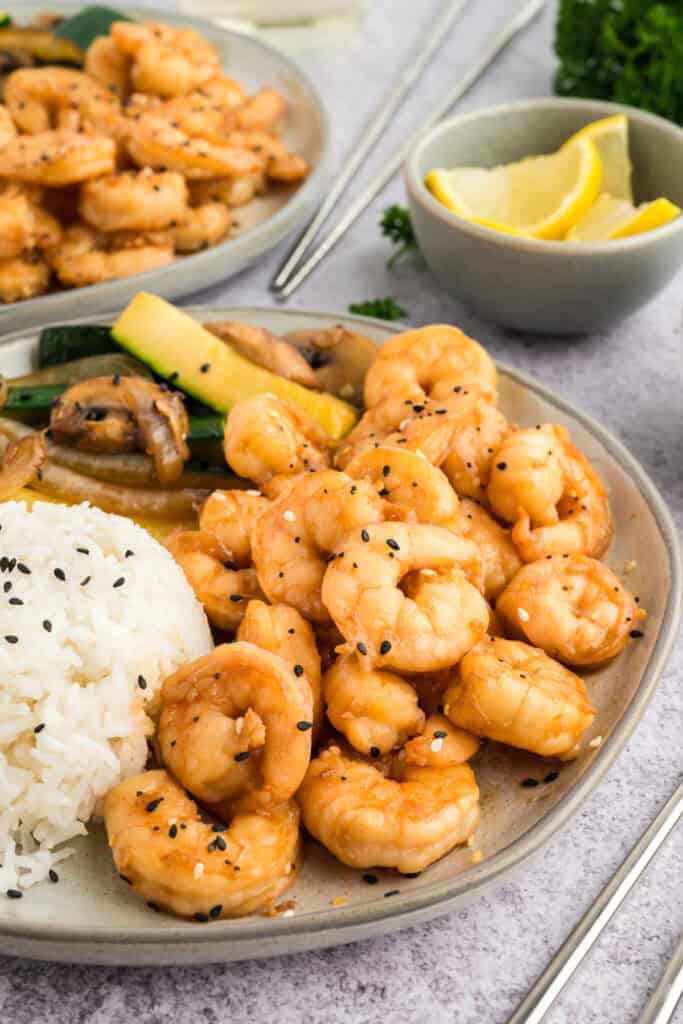 Plate of Hibachi Shrimp with white rice and hibachi vegetables, served with lemon wedges on the side.