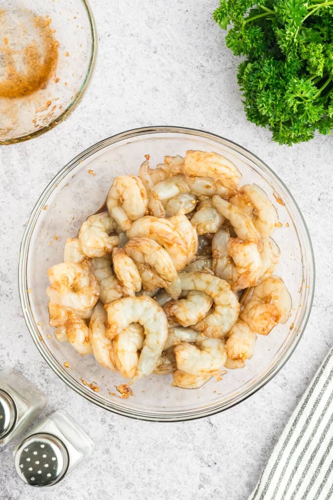 Raw shrimp coated in Hibachi Shrimp marinade in a glass mixing bowl.