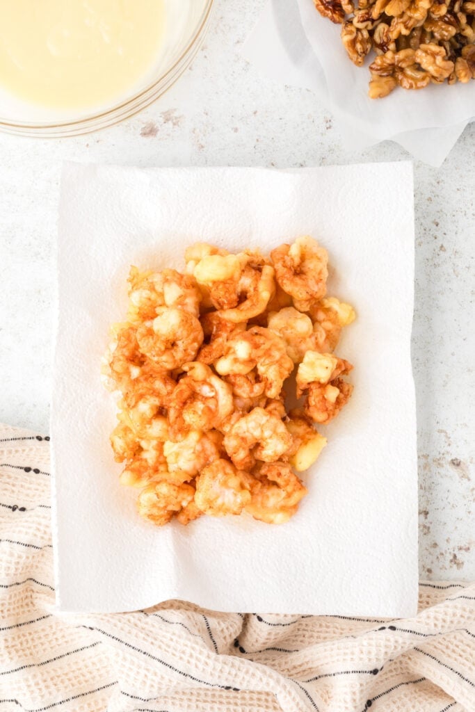 Fried shrimp draining on paper towels for homemade Honey Walnut Shrimp