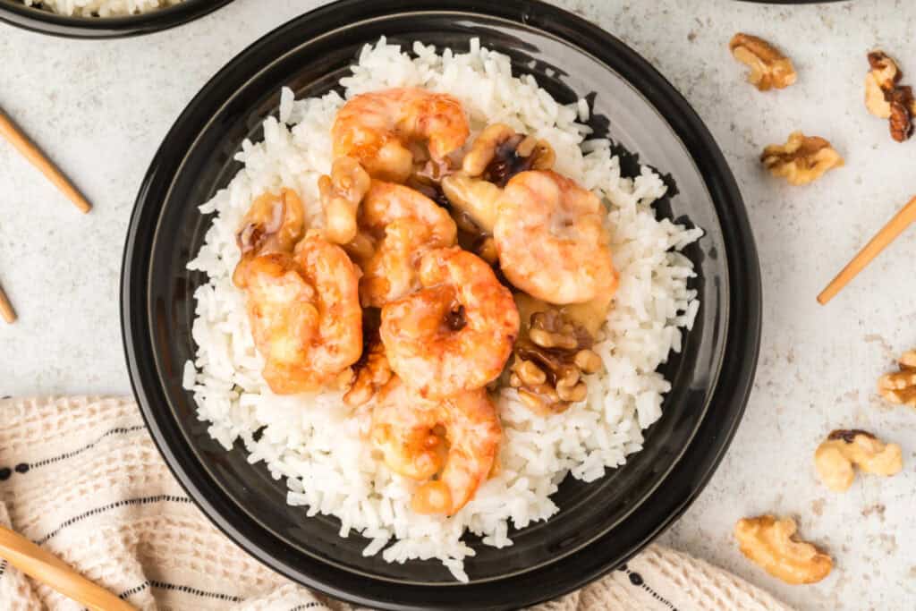 Honey Walnut Shrimp served over steamed white rice in a black bowl