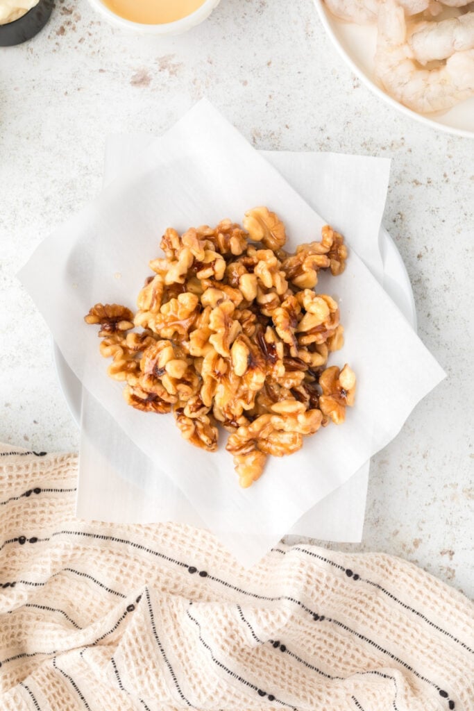 Homemade candied walnuts cooling on parchment paper for Honey Walnut Shrimp