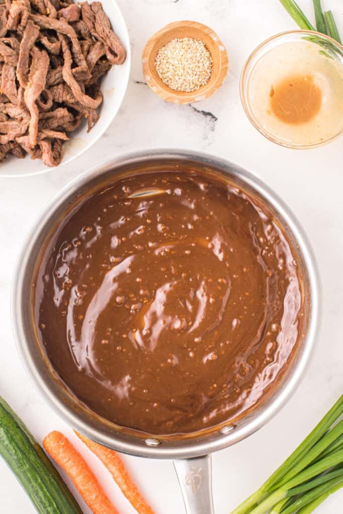 Cooked beef strips returned to thickened bulgogi sauce in a skillet for Korean Beef Bulgogi