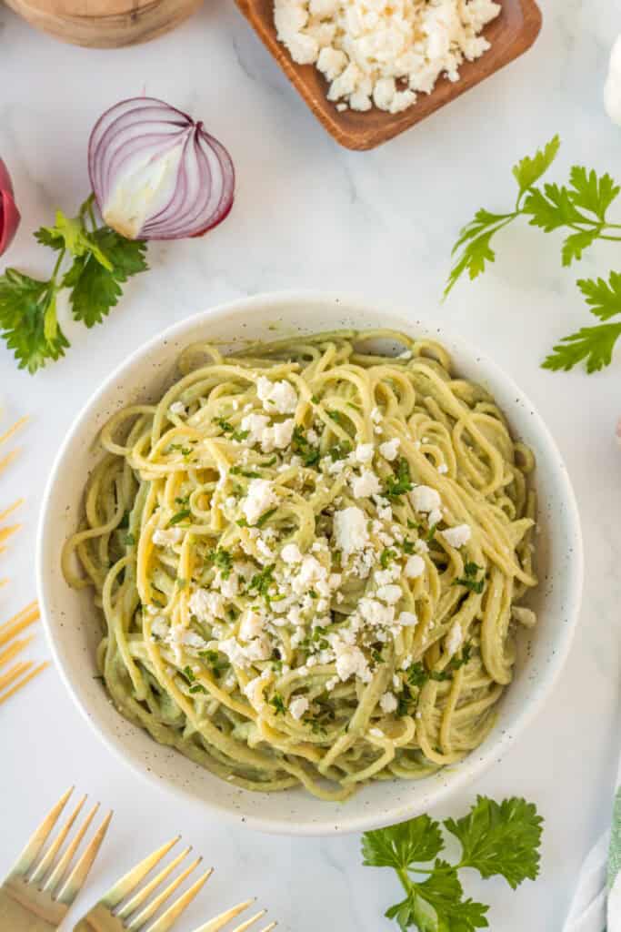 Overhead view of Mexican Green Spaghetti topped with queso fresco and cilantro