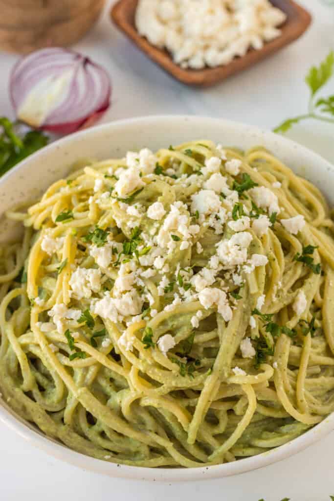 Close-up of creamy Espagueti Verde with queso fresco and fresh cilantro