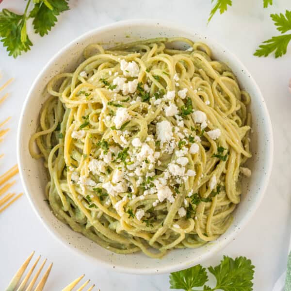 Square image of Mexican Green Spaghetti topped with queso fresco and parsley
