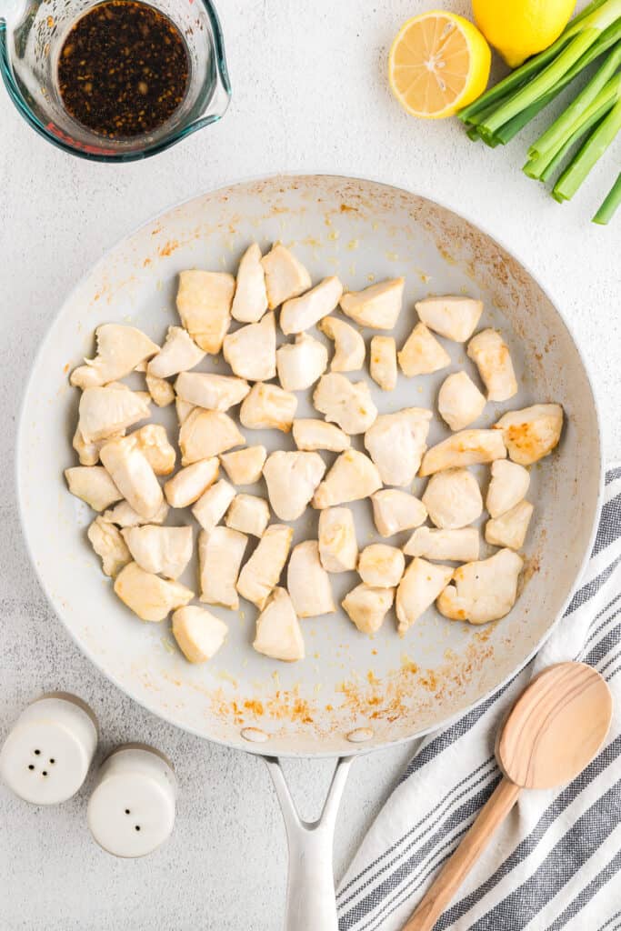 Chicken breast pieces searing in a skillet while making homemade Hibachi Chicken for a quick Japanese steakhouse-style dinner.