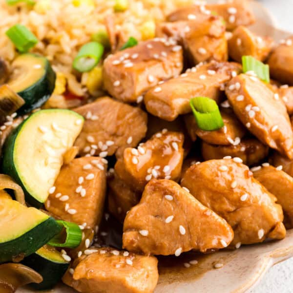 Square image of Hibachi Chicken with fried rice, zucchini, mushrooms, sesame seeds, and green onions for an easy Japanese steakhouse-style recipe.