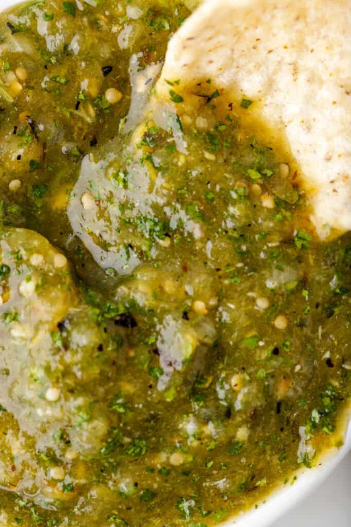 tortilla chip dipping into a bowl of Tomatillo Salsa