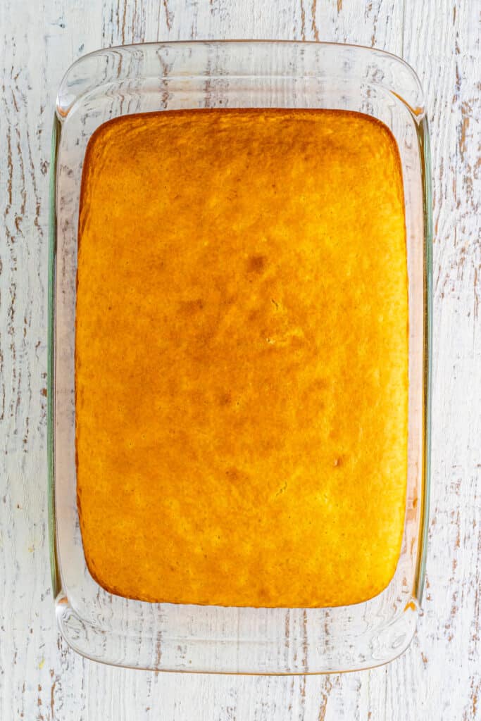 Baked yellow cake in a clear 9x13-inch glass baking dish viewed from above for Banana Split Trifle.