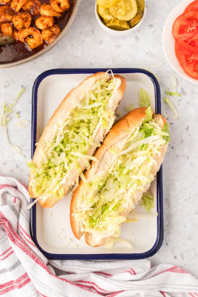 Lettuce added to shrimp po'boy sandwiches