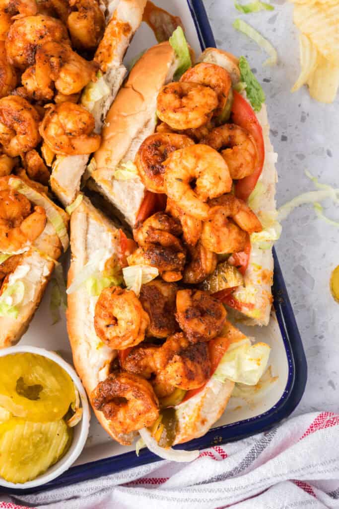 Close-up of seasoned shrimp piled onto a po'boy sandwich