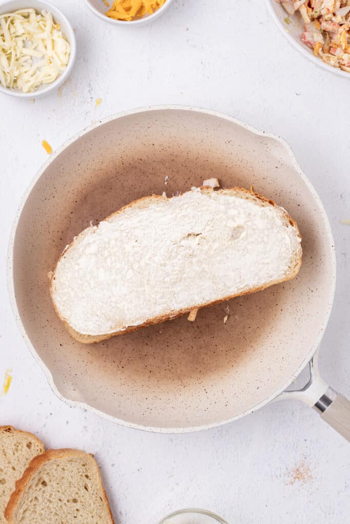 Top slice of bread spread with butter and placed over the Cheesy Crab Melt filling in a skillet