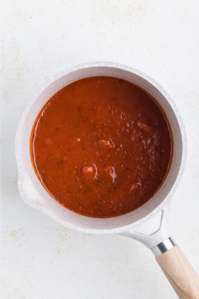 Marinara sauce warming in a small saucepan