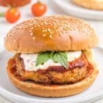 Chicken Parm Burger with marinara sauce, mozzarella cheese, and basil on a sesame seed bun