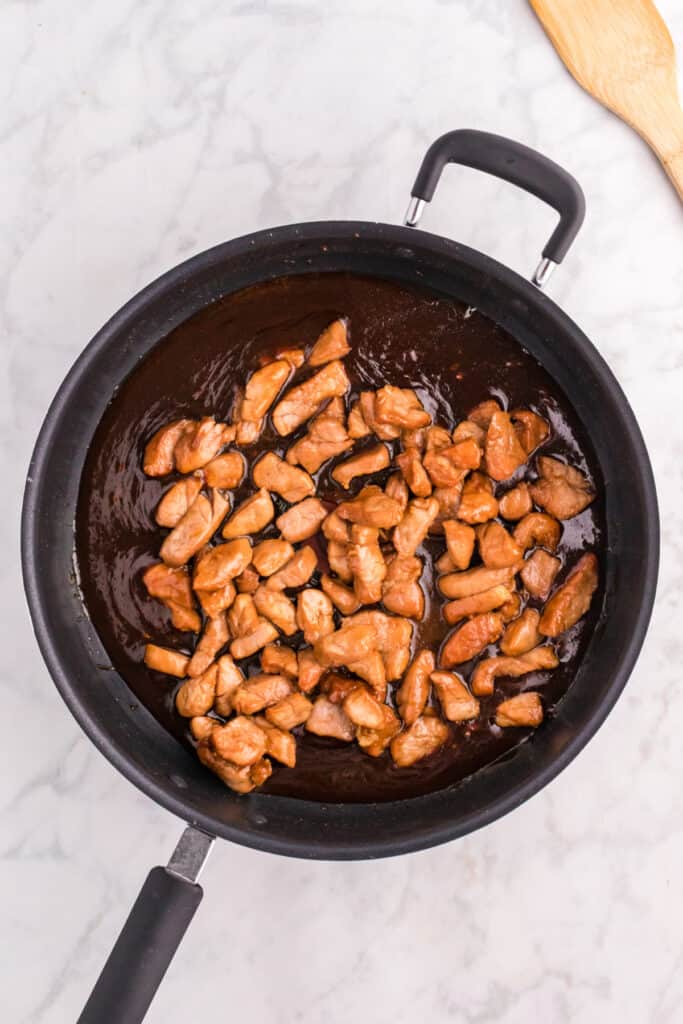 Cooked pork returned to the skillet with the thickened Mongolian sauce