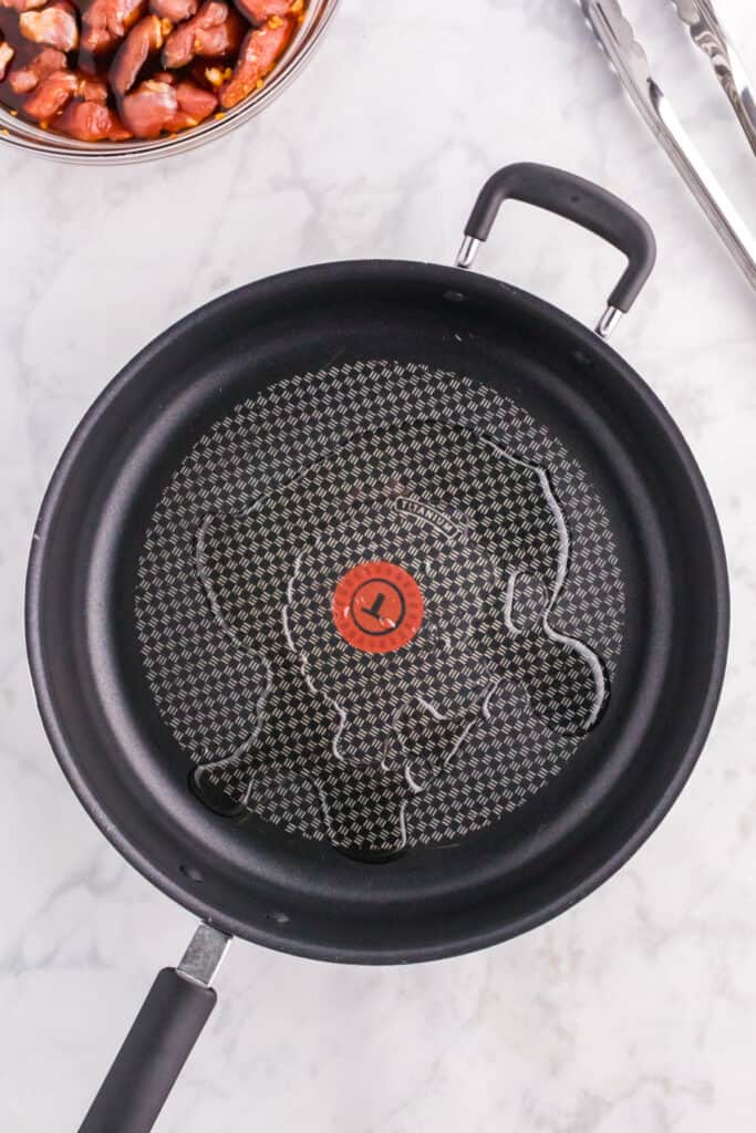 Vegetable oil heating in a skillet for cooking Mongolian Pork