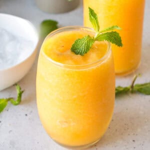 Square image of a Frozen Peach Bellini garnished with mint, perfect for recipe cards and social media.