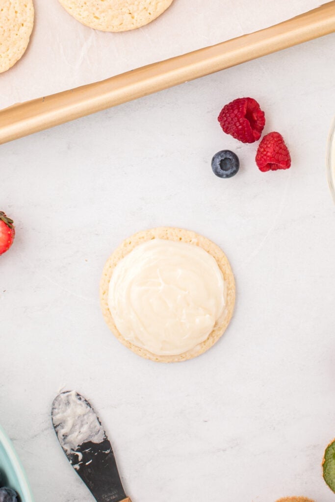 Frosted sugar cookie ready to be decorated with fresh fruit.