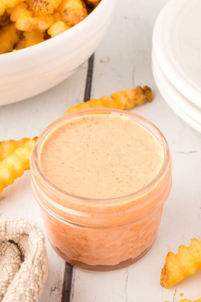 Homemade Fry Sauce in a small glass jar served with crispy crinkle-cut French fries.