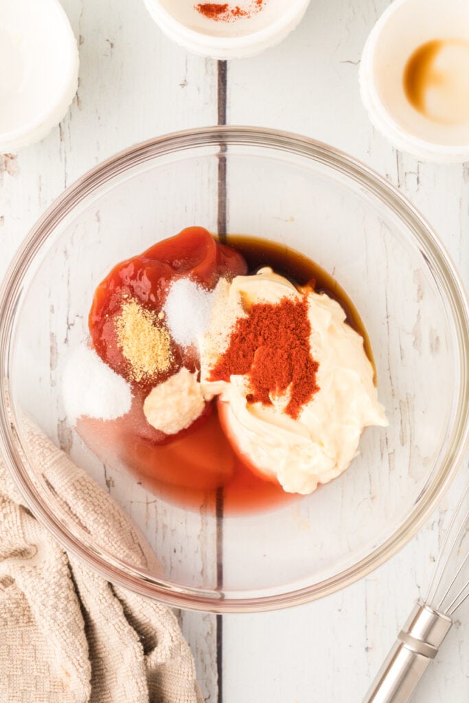 Mayonnaise, ketchup, vinegar, and seasonings combined in a glass bowl to make Fry Sauce.