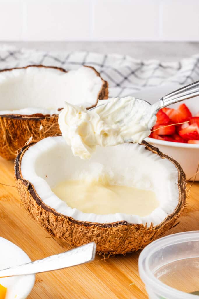 Adding the sweetened cream cheese mixture to shaved ice for Halo Halo.
