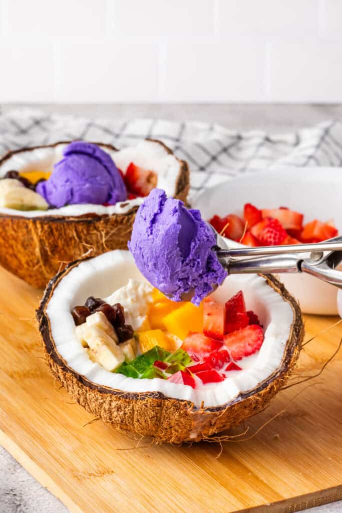 Adding scoops of ube ice cream to homemade Halo Halo.