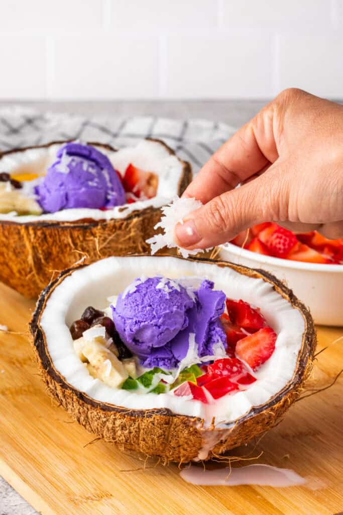 Topping Halo Halo with shredded coconut flakes.