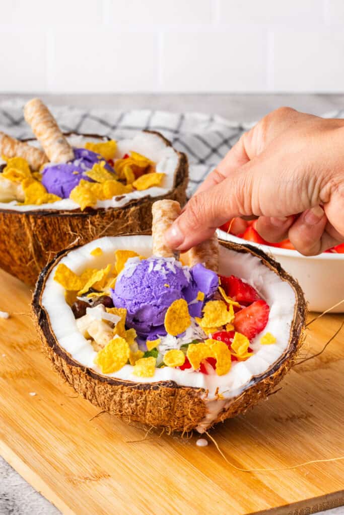 Garnishing Halo Halo with rolled coconut wafer cookies.