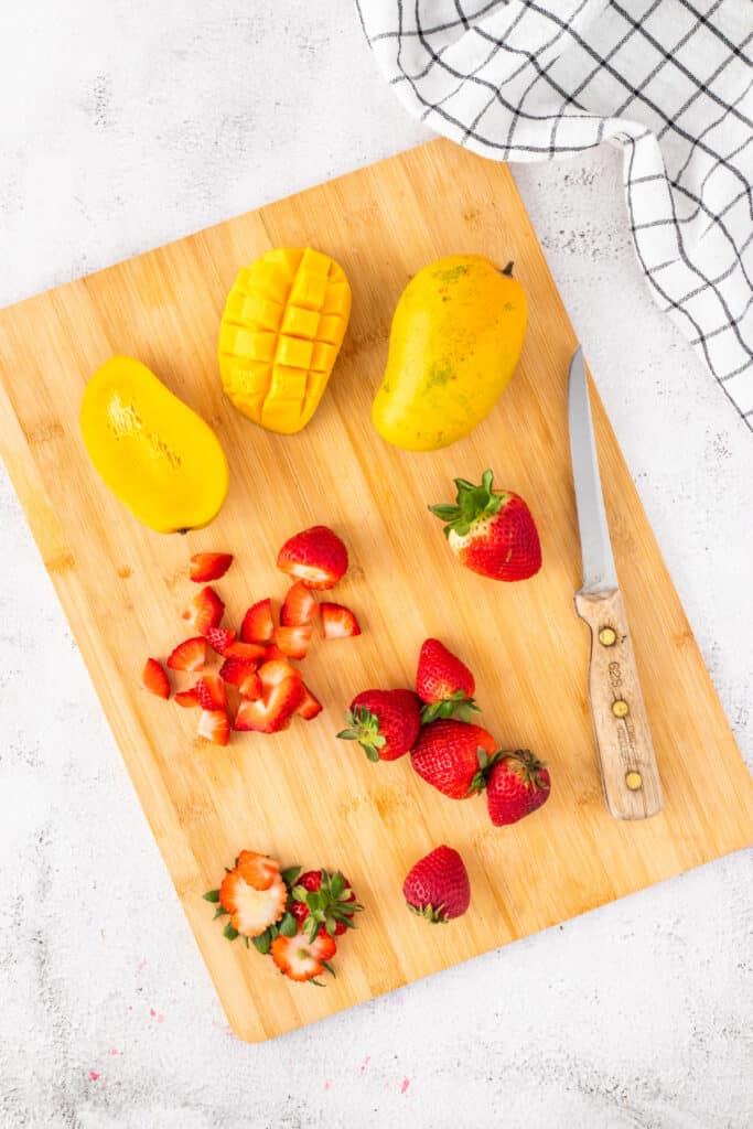 Slicing fresh mangoes and strawberries for homemade Halo Halo.