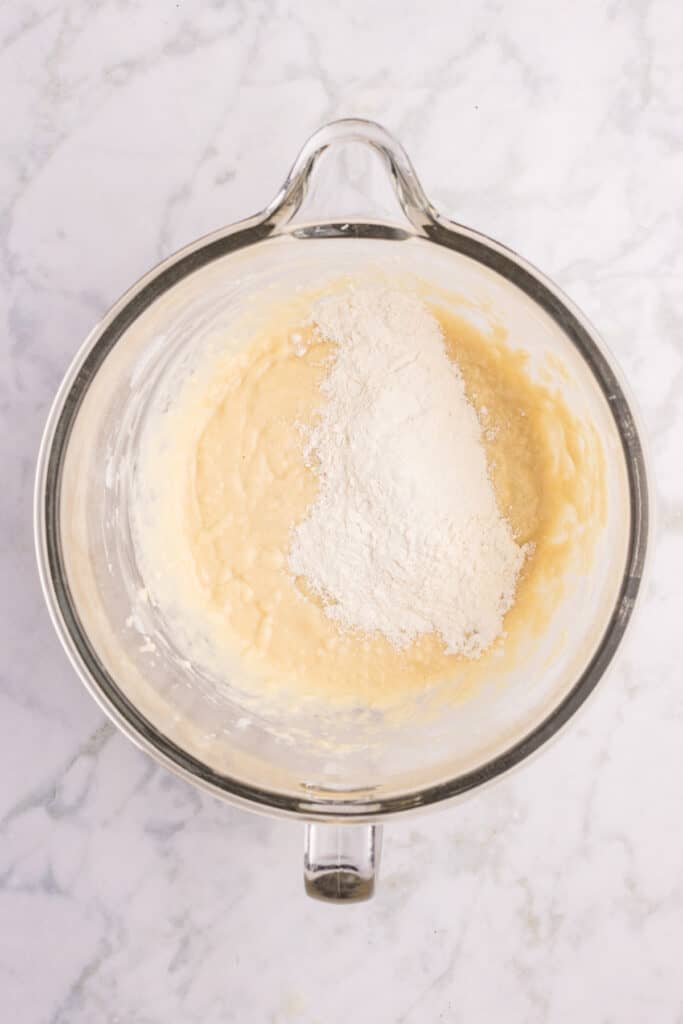 Flour being added to homemade hamburger bun dough in a stand