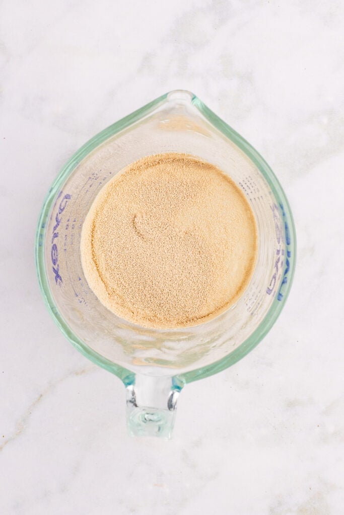 Active dry yeast blooming in warm water for homemade hamburger buns