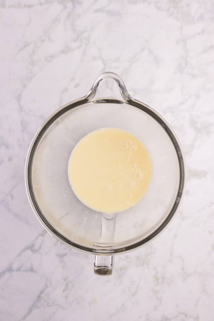 Warm milk mixture poured into the bowl of a stand mixer