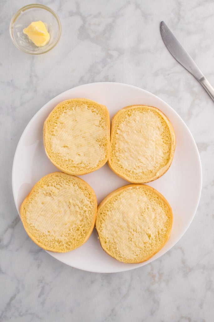 Hamburger buns spread with butter before toasting.