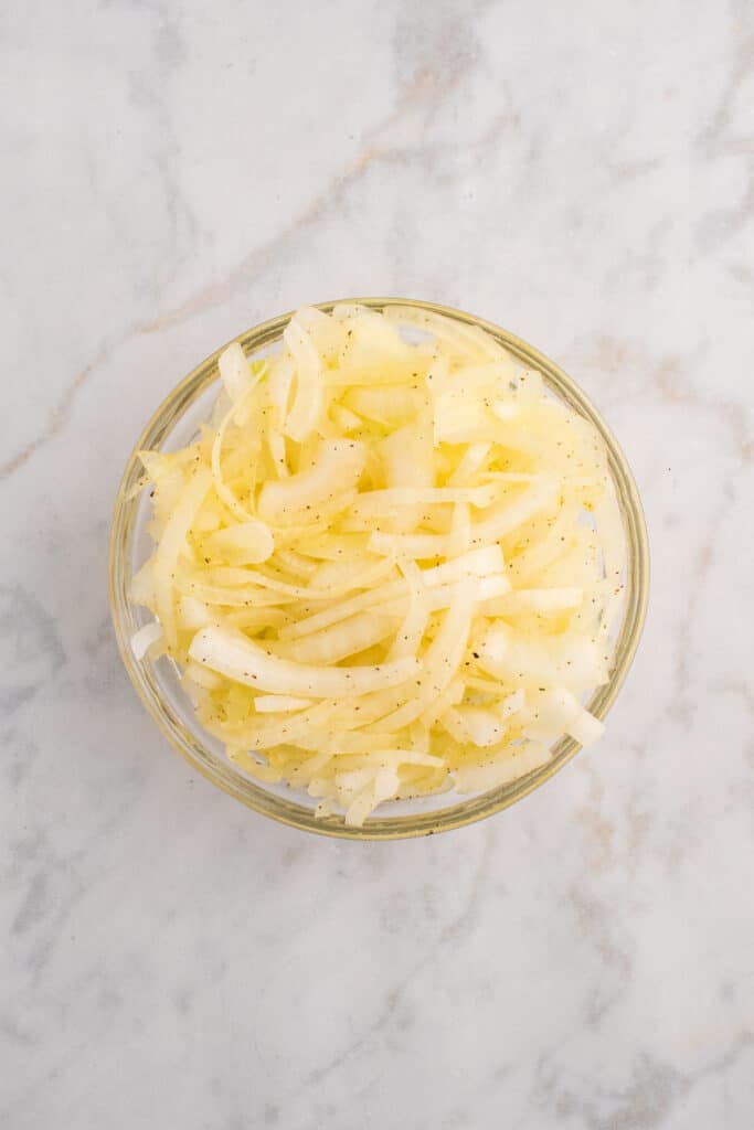 Bowl of thinly sliced onions for Oklahoma Onion Burgers.