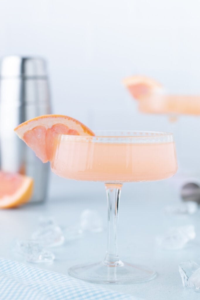 Fresh grapefruit Paloma Cocktail served in a coupe glass with grapefruit garnish.