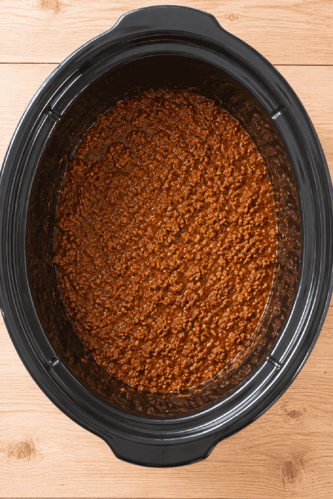 Homemade hot dog chili fully cooked in the slow cooker with a rich, smooth texture.