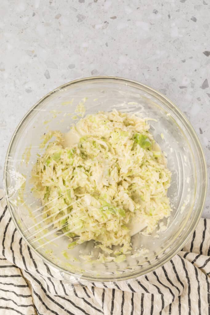 Bowl of Southern-Style Slaw covered with plastic wrap before chilling in the refrigerator.