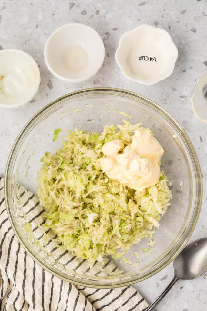 Mayonnaise added to seasoned cabbage while preparing Southern-Style Slaw.